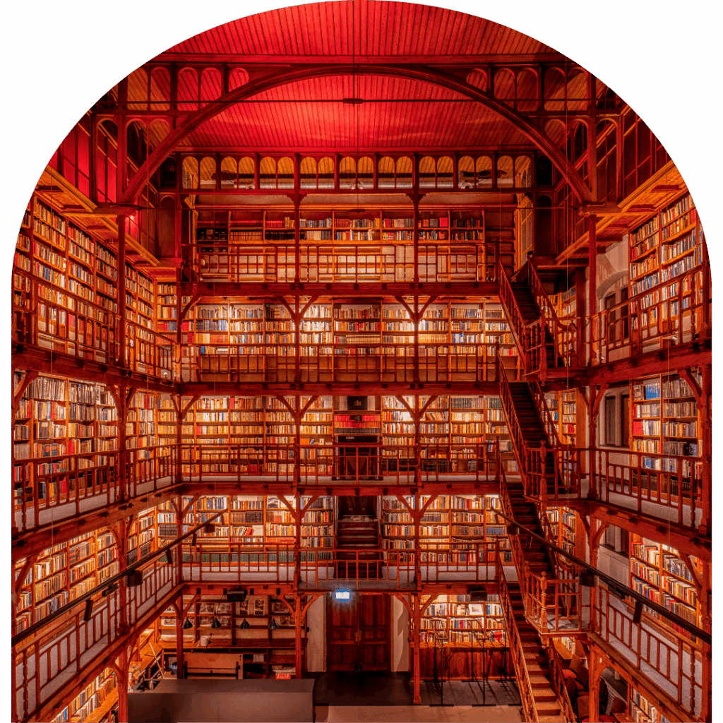 Grote sfeervolle bibliotheekruimte met houten galerijen, trappen en duizenden boeken in vergaderruimte De Boekerij