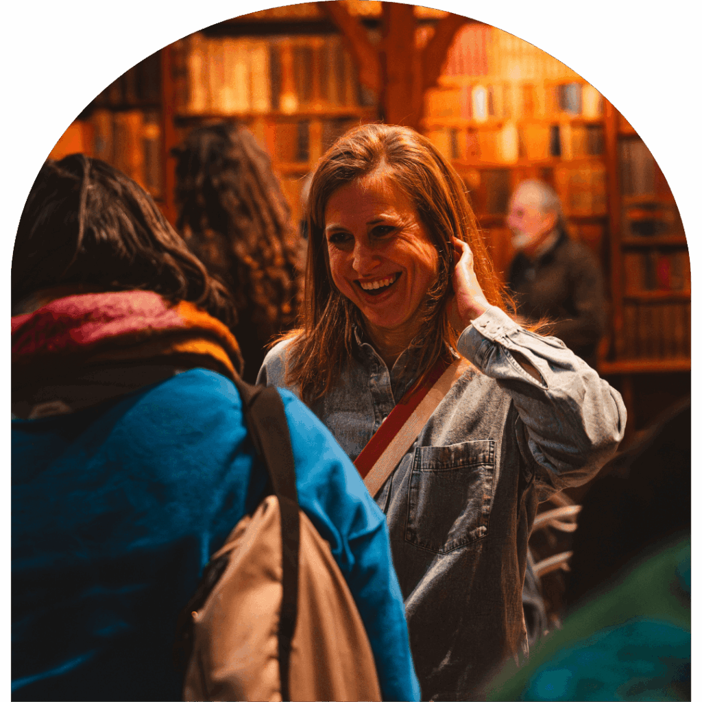 Bezoekers in gesprek in de monumentale bibliotheek van De Boekerij in Nijmegen tijdens een zakelijke bijeenkomst of evenement.