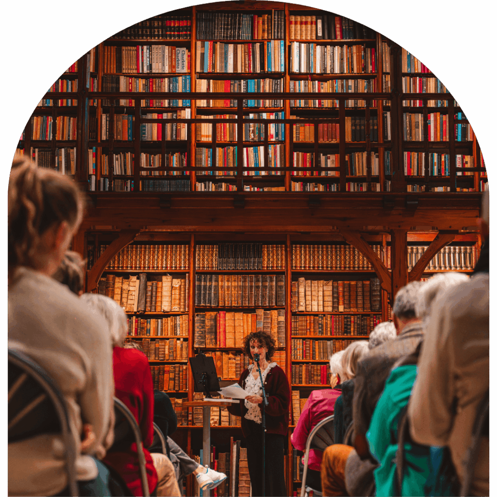 Evenement in De Boekerij in Nijmegen met publiek en spreker tussen historische boekenkasten in monumentale bibliotheek.