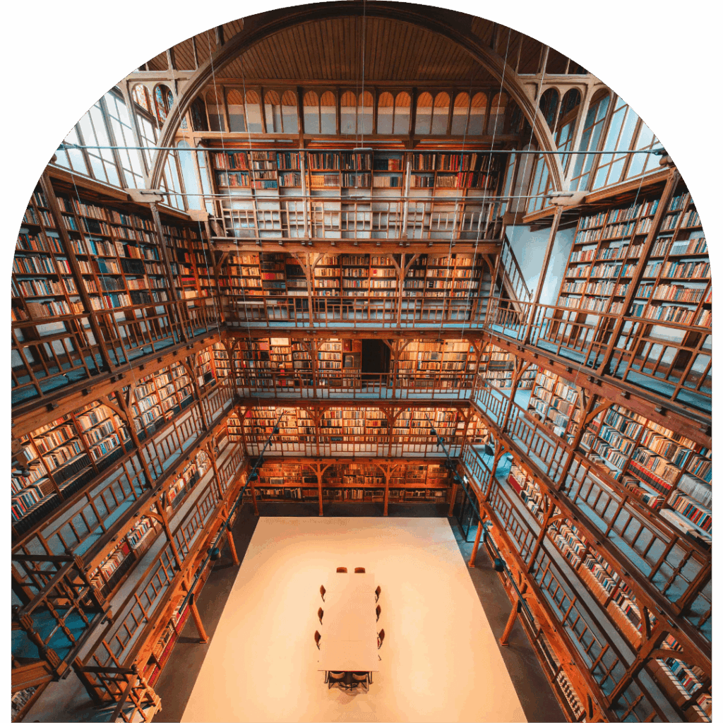 Historische vergaderlocatie De Boekerij in Nijmegen met hoge boekenkasten, houten galerijen en vergadertafel in monumentale bibliotheek.